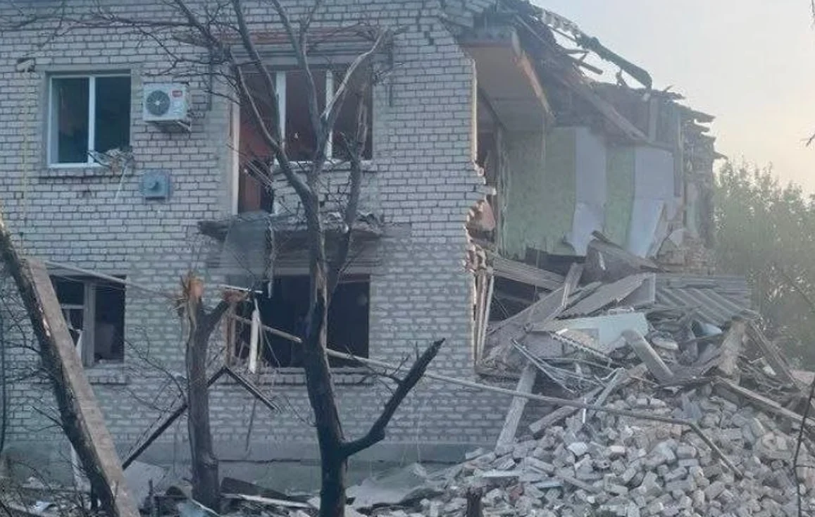 Зруйнована двоповерхова цегляна будівля з купою уламків і пошкодженими деревами