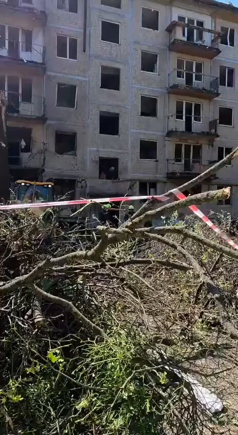Пошкоджений житловий будинок після обстрілу з уламками дерев і стрічкою